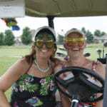 two women in funny glasses on golf cart